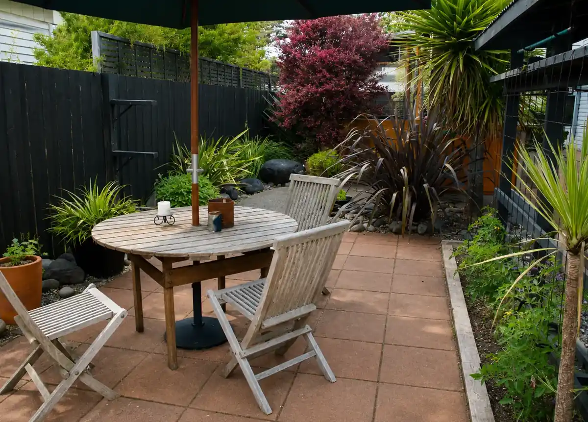 Sunny outdoor patio with a wooden table, chairs and umbrella